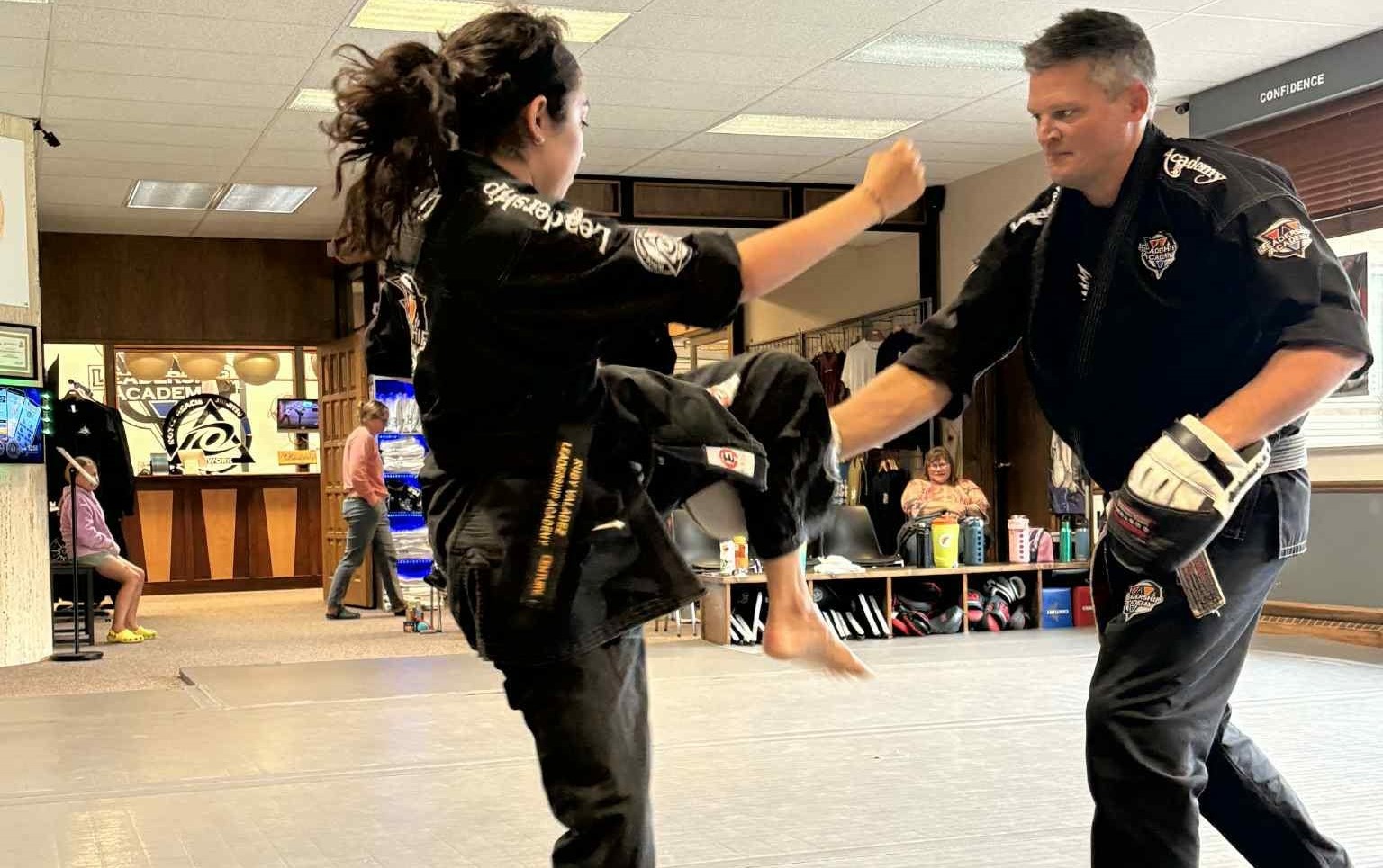 Adult Taekwondo student practicing kicks with an instructor at Leadership Academy