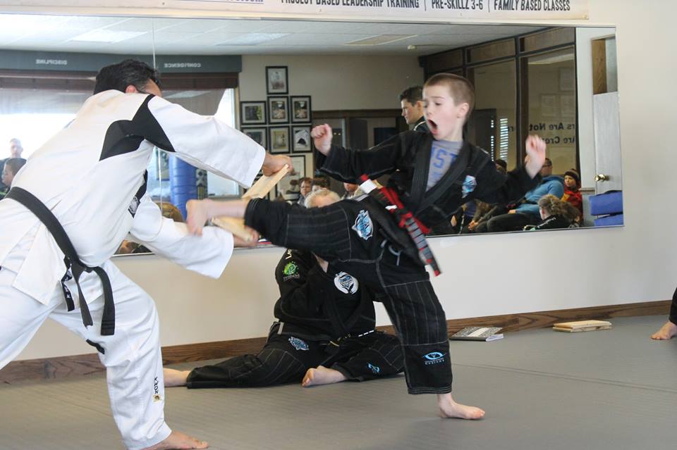 Leadership Academy black belts standing in front of the school logo