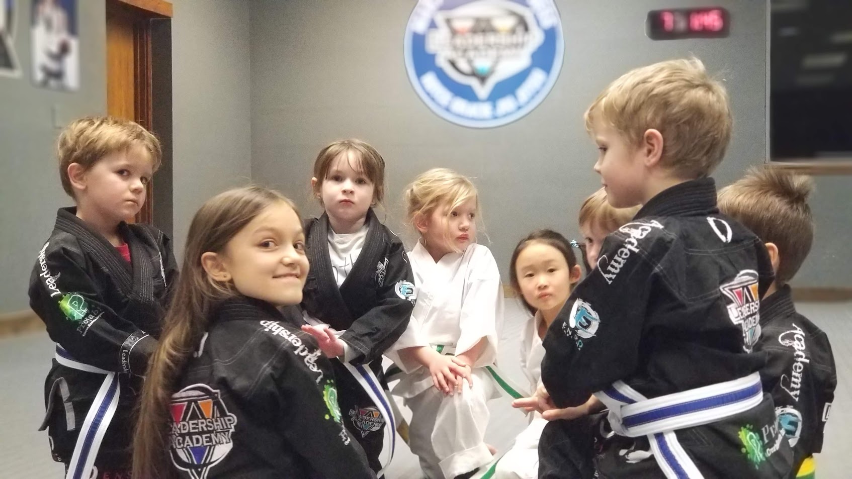 Young martial arts students sitting together in class