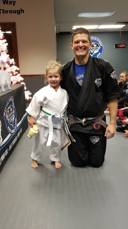 Lil Dragons student smiling with coach after a belt promotion
