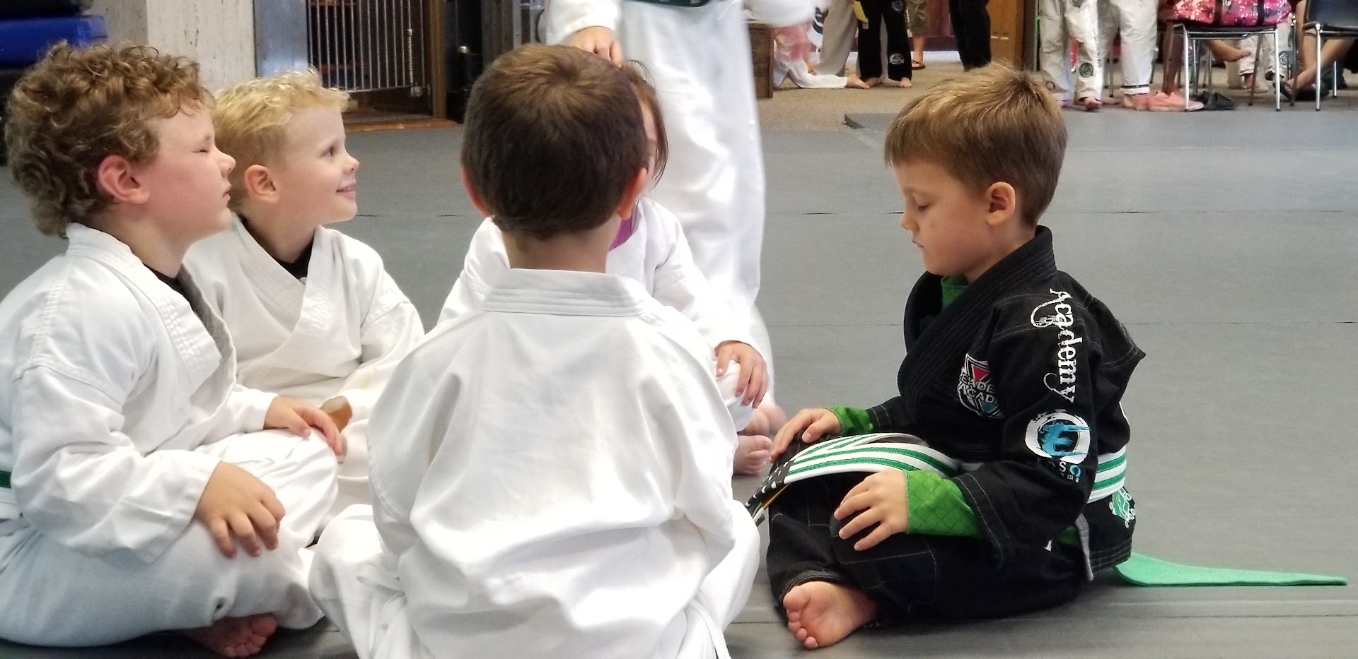 Lil Dragons students sitting in a small group on the mat