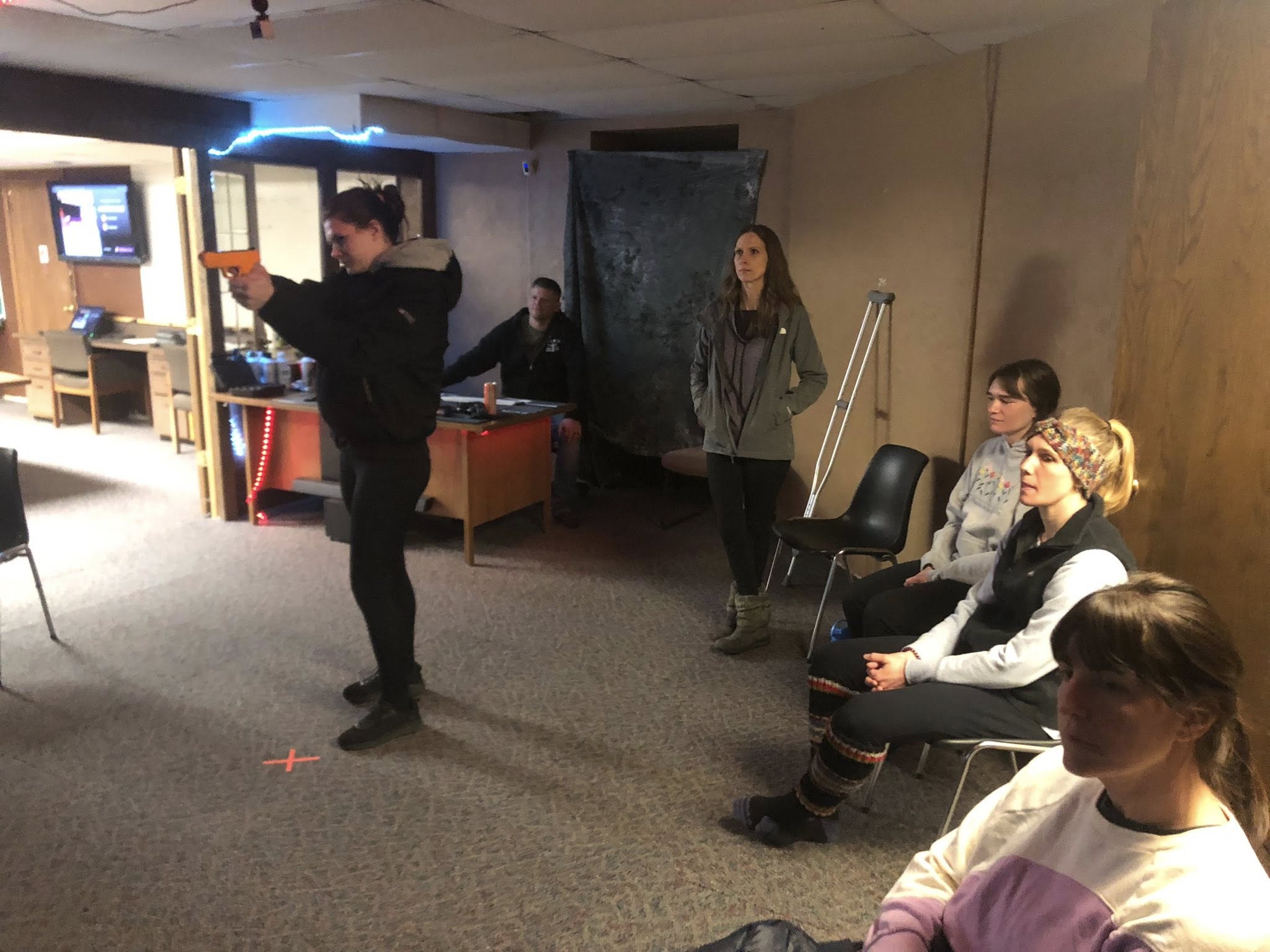 Indoor laser simulator class with students watching a training drill