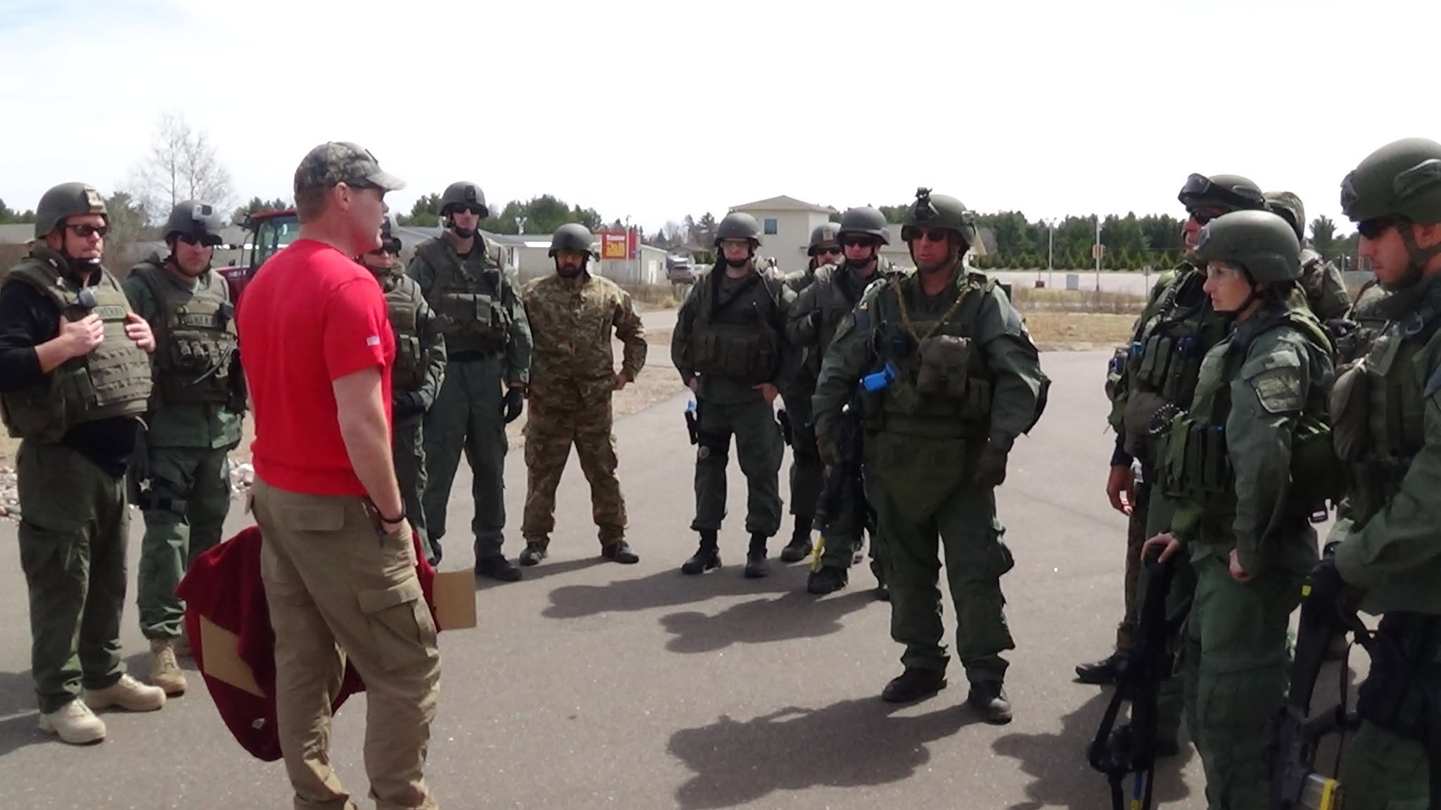 Tom Ahlborn in a red shirt briefing a tactical team